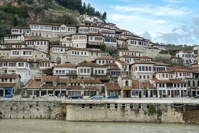 Buildings by sea against sky in town