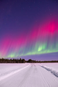 Red northern lights against sky at night