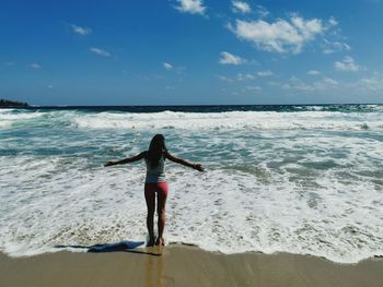 Rear view of woman walking on beach