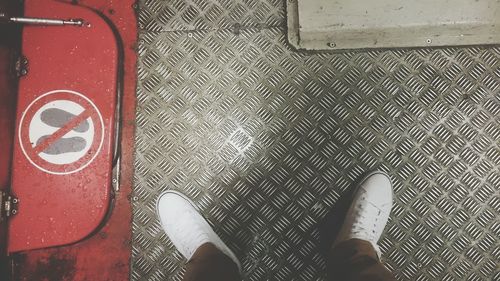 Low section of person standing on tiled floor