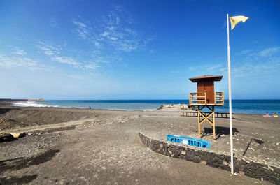 Lifeguard hut on beach against sky