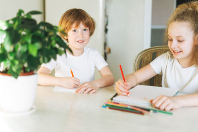 Portrait of happy friends sitting on table