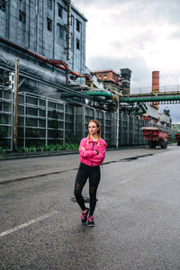 Full length of woman standing on road in city