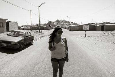 Full length of woman standing on road in city