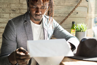 Close-up of serious young man reading menu in cafe