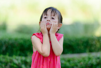 Portrait of cute girl standing in pink outdoors