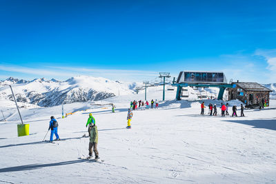 Skiers and snowboarders exiting from ski lift on the top of the mountain in andorra