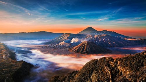 Scenic view of volcanic landscape against sky during sunset