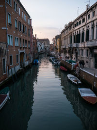 Canal amidst buildings in city against sky