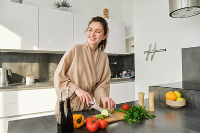 Portrait of young woman standing at home