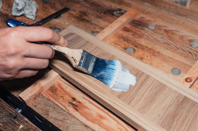 Varnishing a wooden drawer, carpentry workshop. varnish is applied to a wooden board with a brush