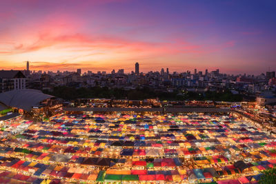 High angle view of illuminated city against sky at sunset