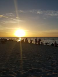 Group of people on beach at sunset