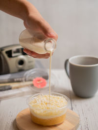 Close-up of milk poured cheese dessert cup on table