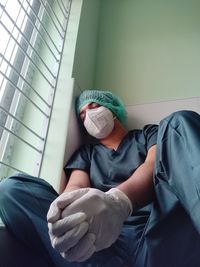 Midsection of man sitting against wall