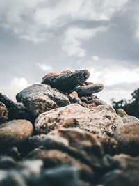 Close-up of stones on rock against sky