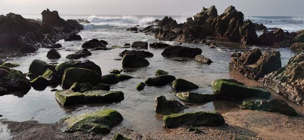 Rocks on beach against sky