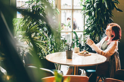 Woman reading good news on mobile phone during rest in coffee shop.