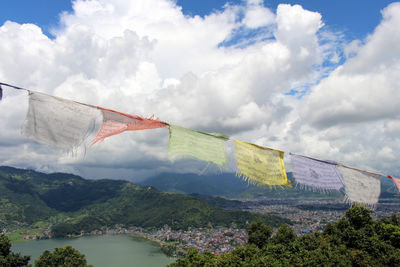 Low angle view of flags hanging on mountain against sky