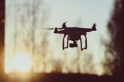 Low angle view of drone flying against sky