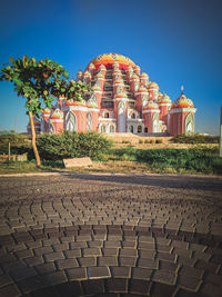 Cobblestone street by building against sky