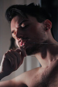 Close-up portrait of shirtless man at home