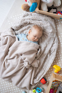 High angle view of baby boy sleeping on bed at home