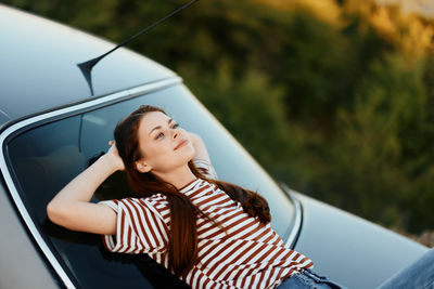 Low angle view of young woman in car