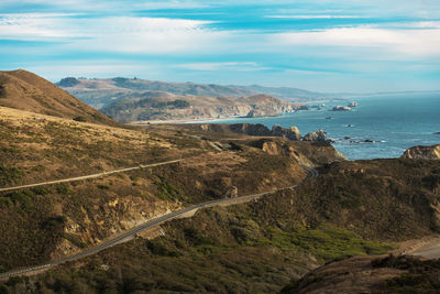 Scenic view of sea and mountains against sky