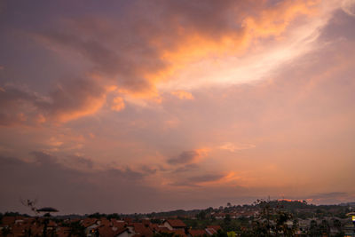 View of cityscape against cloudy sky at sunset