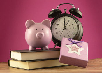 Electric lamp on table against pink background