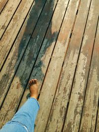 Low section of person standing on wooden floor