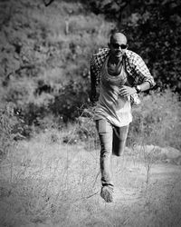 Full length of young man running on field