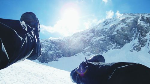 Low section of person against mountain against sky on sunny day