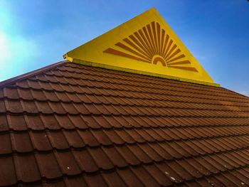 Low angle view of roof of building against blue sky