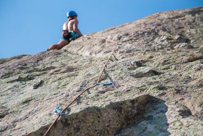 Low angle view of friends on rock against sky