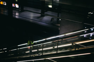 High angle view of woman on illuminated escalator at subway station