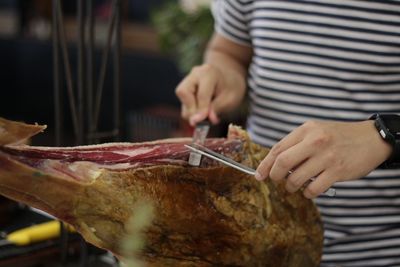 Close-up of man cutting meat