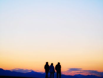 Silhouette people standing against sky during sunset