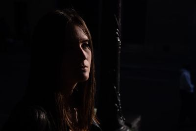 Young woman looking away in darkroom