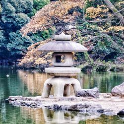 Built structure on rock by lake