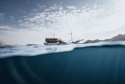 Sailboats moored on sea against sky