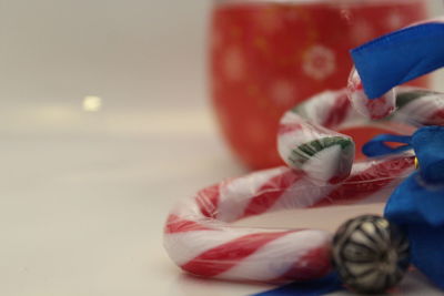 Close-up of candy canes with blue ribbons on table