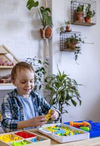 Cute boy playing with toy in classroom