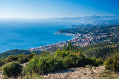 High angle view of townscape by sea against sky