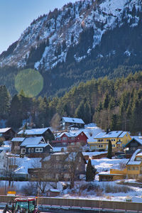 Houses on snowcapped mountain against sky