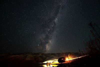 Low angle view of silhouette trees against sky at night