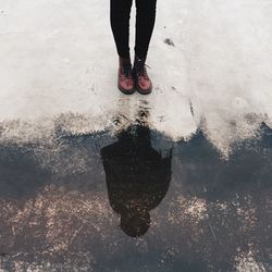 Low section of man with reflection in water