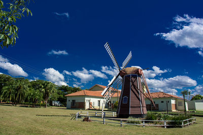 Traditional windmill on field against sky