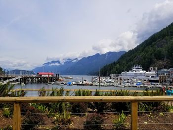 Boats moored in harbor against sky